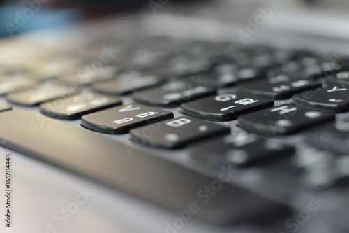 Perspective of the thai keyboard of a laptop in black blur