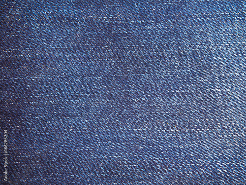 A full page of blue cotton material, denim fabric close-up. Macro photo texture of jeans. View of top on background texture close-up.