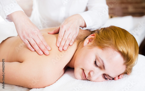 Woman taking massage in salon