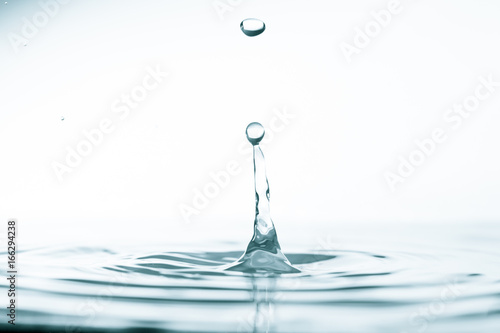 Water drop and splash on water surface on blue background