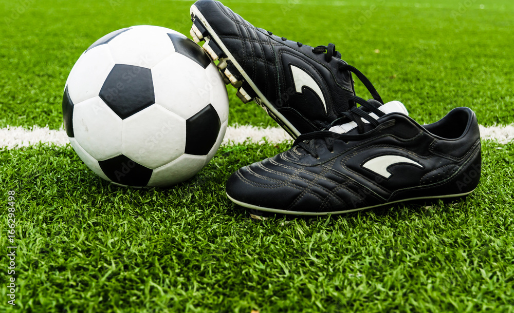 Soccer Ball and Shoes on a Green Grass Field.