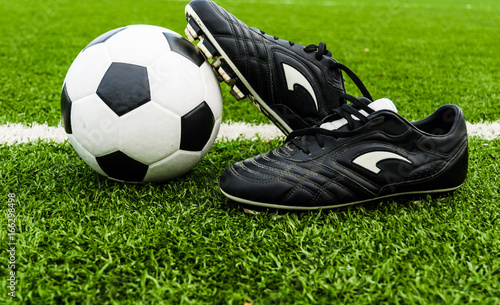 Soccer Ball and Shoes on a Green Grass Field.