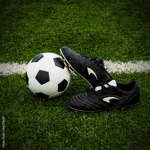 Soccer Ball and Shoes on a Green Grass Field.