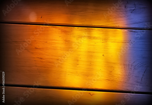 Wooden floor background with multicolored light from stained glass window
