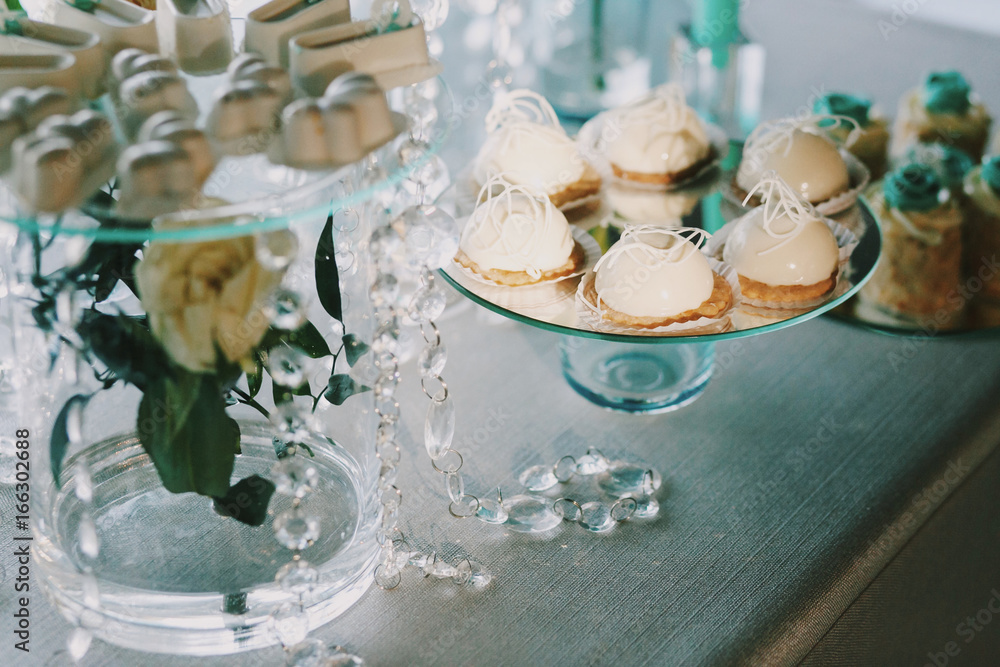 White sweets served on dinner table with crystal chains White sweets served on dinner table with crystal chains