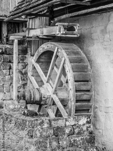 Old mill water wheel without water, black and white image.