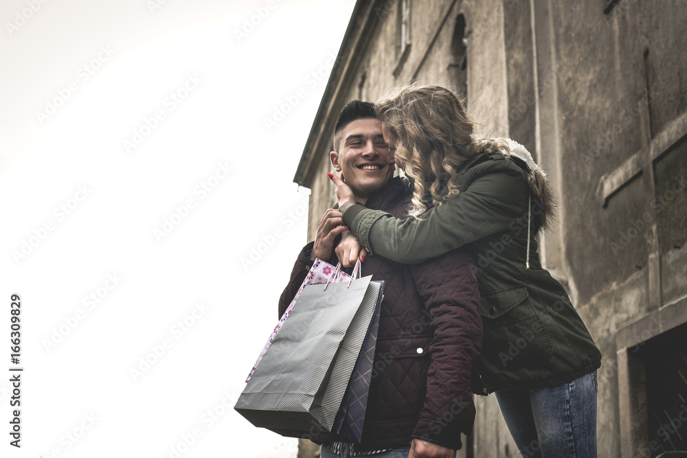 Obraz premium Couple in shopping together. Cheerful couple standing on street. Looking each other.