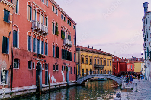 Sunset time Venice: warm light, bright buildings, boats and bridges. © juhrozian
