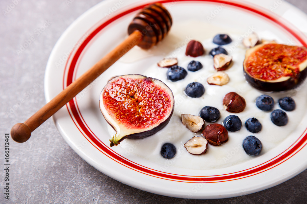 Yogurt with berries fresh figs, blueberries and honey.Food or Healthy diet concept.Super Food.selective focus. Yogurt with berries fresh figs, blueberries and honey.Food or Healthy diet concept.Super Food.selective focus.