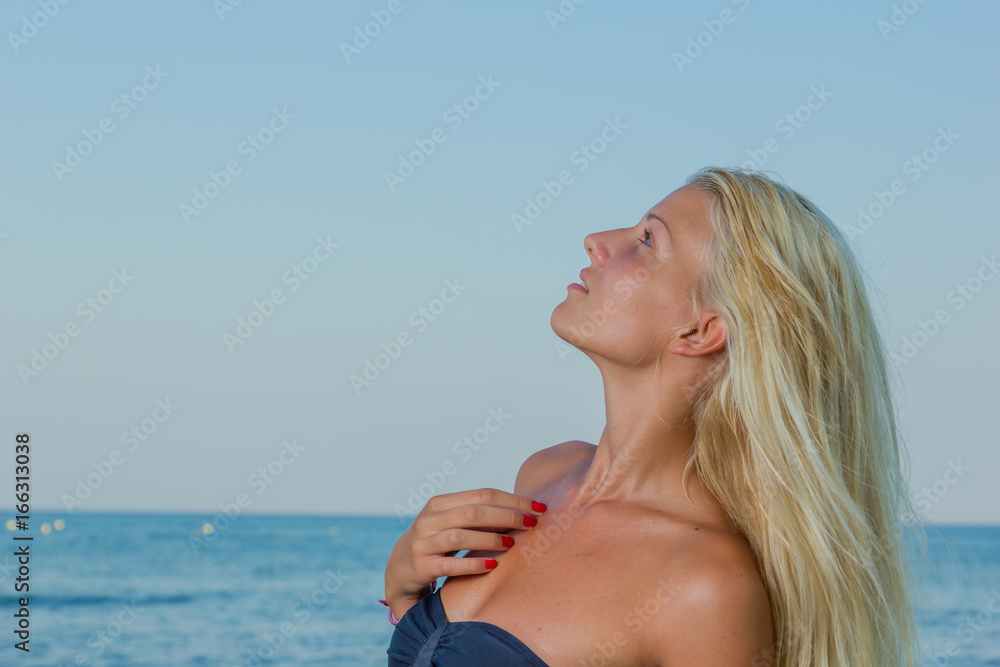 Young woman in black bikini posing in the sea