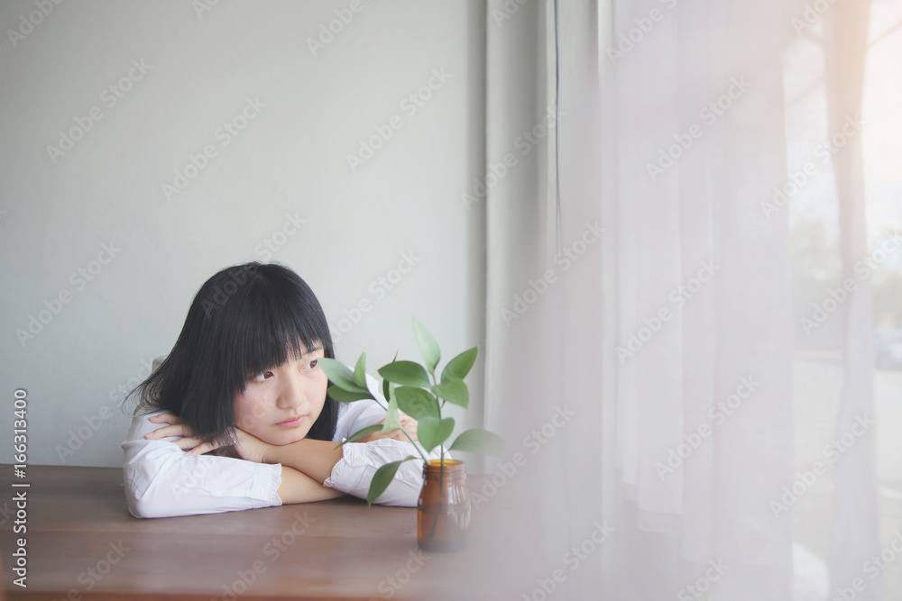 Asian young woman thinking and looking portrait in coffee shop cafe Asian young woman thinking and looking portrait in coffee shop cafe