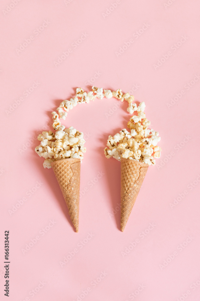 Popcorn in ice cream cones on pink background. Top view. Vertical. Popcorn in ice cream cones on pink background. Top view. Vertical.