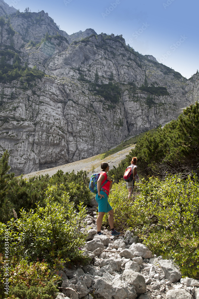 Hikers walking on hike in mountain nature landscape in Slovenian mountains