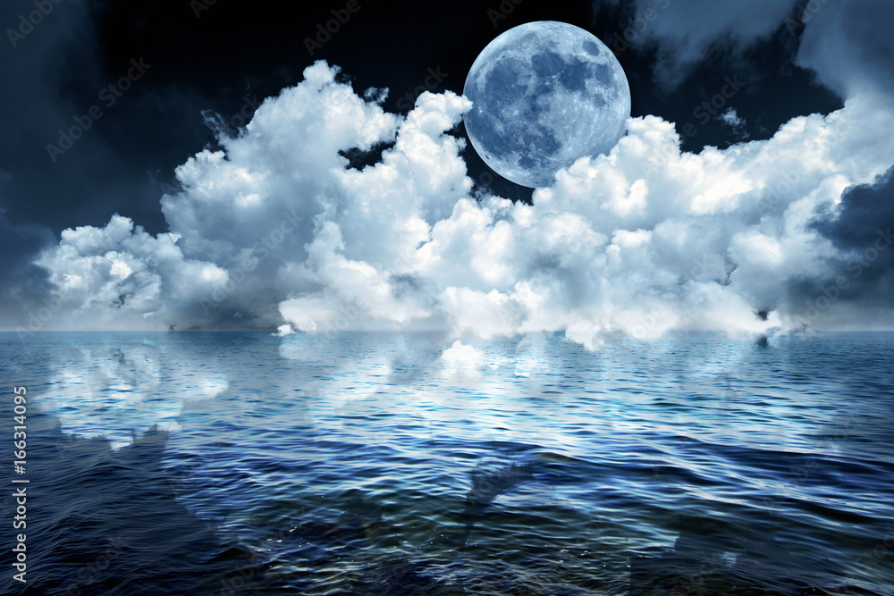 Naklejka premium Big full moon in night sky over the ocean reflecting in calm water