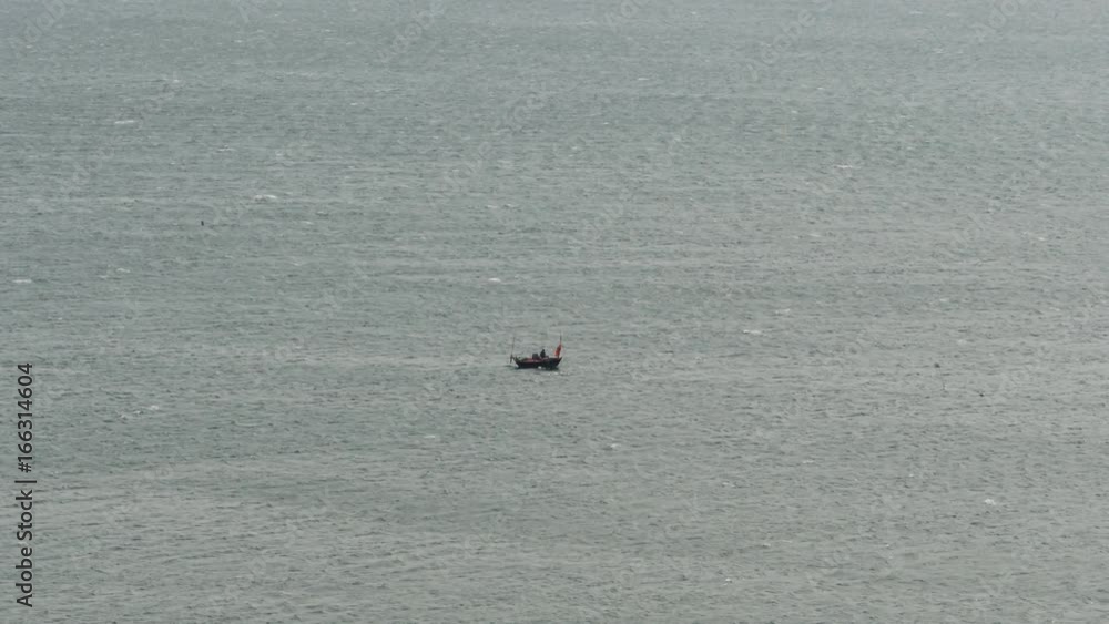 A small boat with a fisherman in the middle of a huge ocean A small boat with a fisherman in the middle of a huge ocean