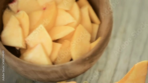 Slicing orgenic peach on wood cutting board photo