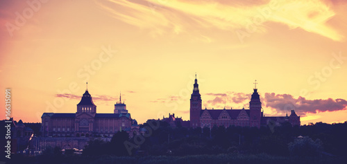 Vintage toned silhouette of Szczecin waterfront after sunset, Poland.