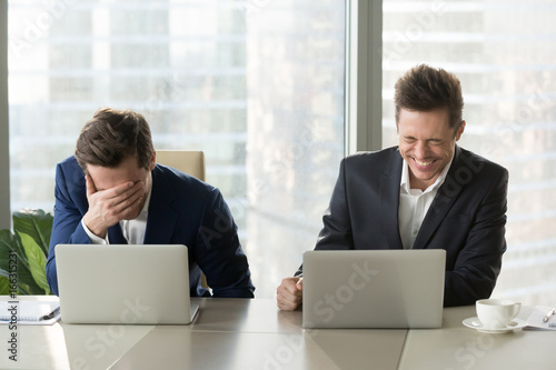 Photos Two businessmen laughing out loud at workplace, office workers screaming with la
