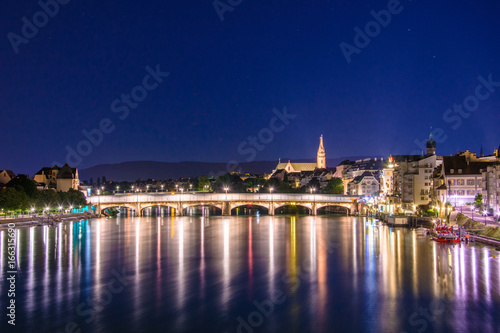 Night view of the Old Town of Basel with red stone Munster cathedral and the Rhine river, Switzerland.
