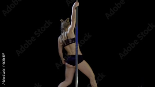 A young girl slowly turns on a pylon