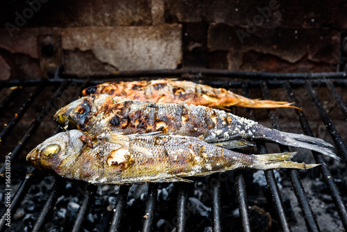 Making fish on a bbq barbecue grill over hot coal.