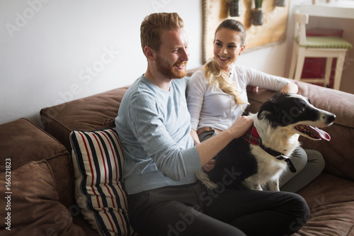 Beautiful couple relaxing at home and loving their dog © NDABCREATIVITY