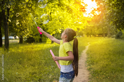 happy little girl having fun with soap bubbles