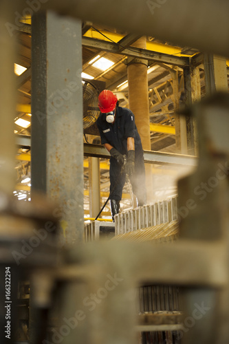 Engineer cleaning machine in factory.