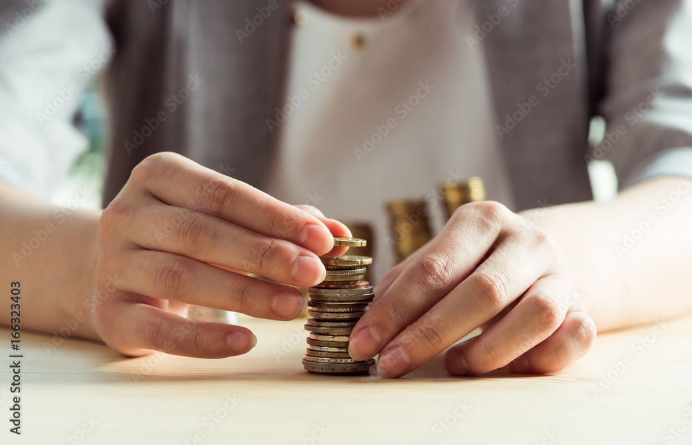 Obraz premium cropped view of woman stacking coins on table, investment concept