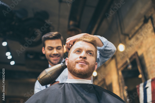 barber drying hair of customer