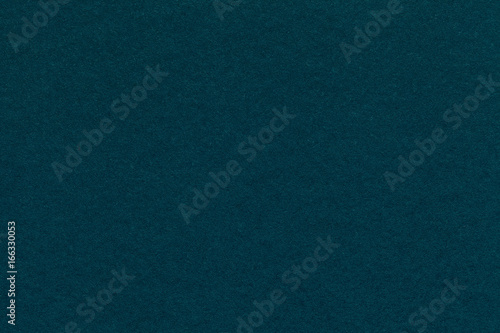 Texture of old navy blue paper closeup. Structure of a dense cardboard. The cyan background.