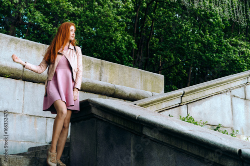 Red-haired girl in pink on the steps