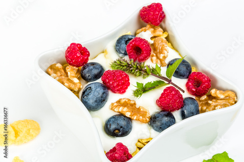Corn flakes with yoghurt, honey, walnuts raspberries and blueberries