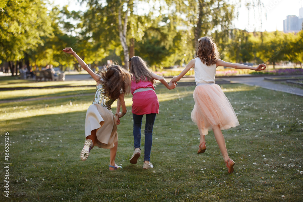 Naklejka premium Three young friends running on a path outdoors smiling