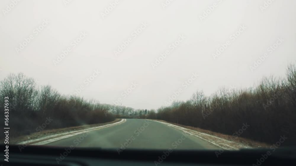 Dashcam view, car riding on asphalt country road trough forest with frozen trees covered in snow. Cold winter cloudy day Dashcam view, car riding on asphalt country road trough forest with frozen trees covered in snow. Cold winter cloudy day