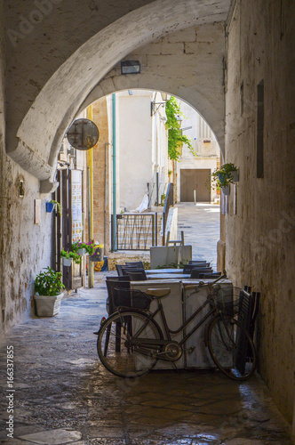 Summer terrace cafe in a narrow arched passageway of Polignano a Mare, Italy. photo