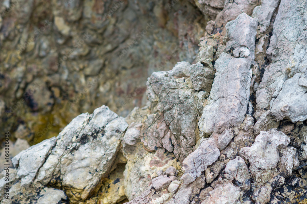 Close-up of a stone in the mountains: colorful rock cliff structure; wild nature