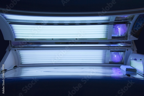 Tanning Salon, Solarium empty tanning bed in modern beauty salon, view on wide open lid and all light bulbs glowing on. Concept of sunbath, beauty lifestyle and healthcare