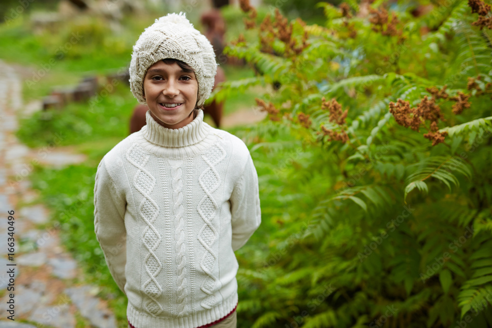 Happy youngster in knitwear spending leisure in park Happy youngster in knitwear spending leisure in park