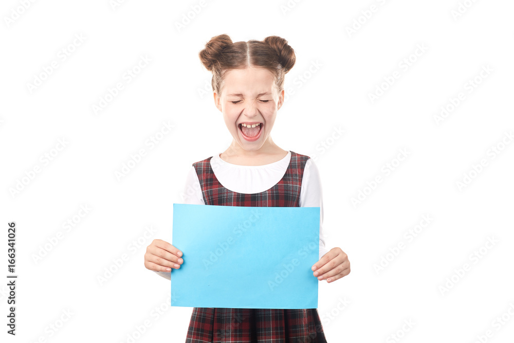 Portrait of excited girl in school uniform holding blank paper against white background Portrait of excited girl in school uniform holding blank paper against white background