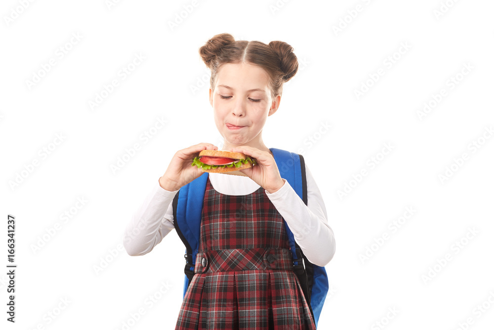 Portrait of cute girl in school uniform eating sandwich against white background Portrait of cute girl in school uniform eating sandwich against white background
