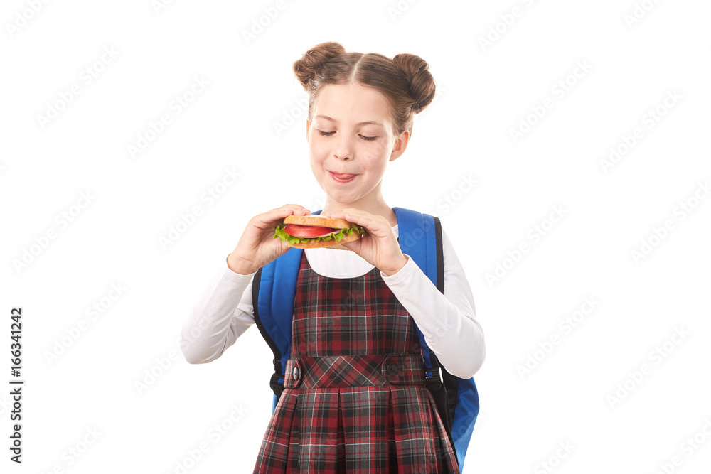 Portrait of cute girl in school uniform eating sandwich against white background Portrait of cute girl in school uniform eating sandwich against white background