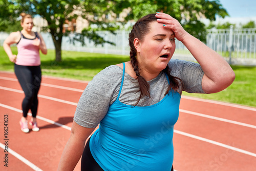 Exhausted runner touching her head with funny facial expression
