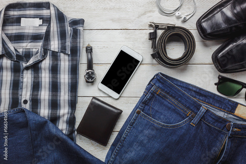 Top view / Flat lay accessoires to travel and technology with man / gentlemen clothing on white wooden table