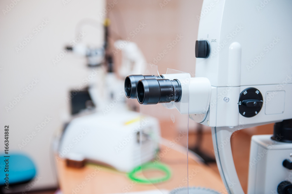 Fragment of ophthalmic laser system in eye surgery clinic. Selective focus, close up. Fragment of ophthalmic laser system in eye surgery clinic. Selective focus, close up.
