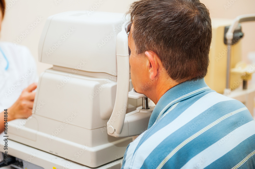 Optometrist measuring patients eye pressure with tonometer. close up, selective focus. Optometrist measuring patients eye pressure with tonometer. close up, selective focus.