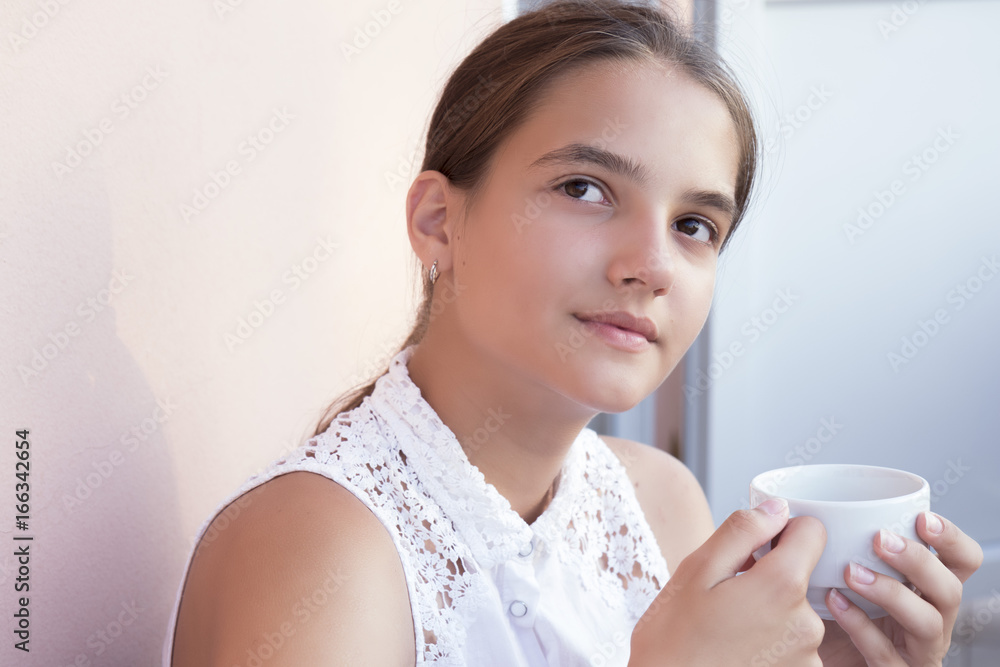 Portrait of pretty young woman holding a coffee cup