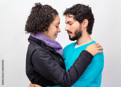 Couple with eyes shut holding each other. © Vergani Fotografia