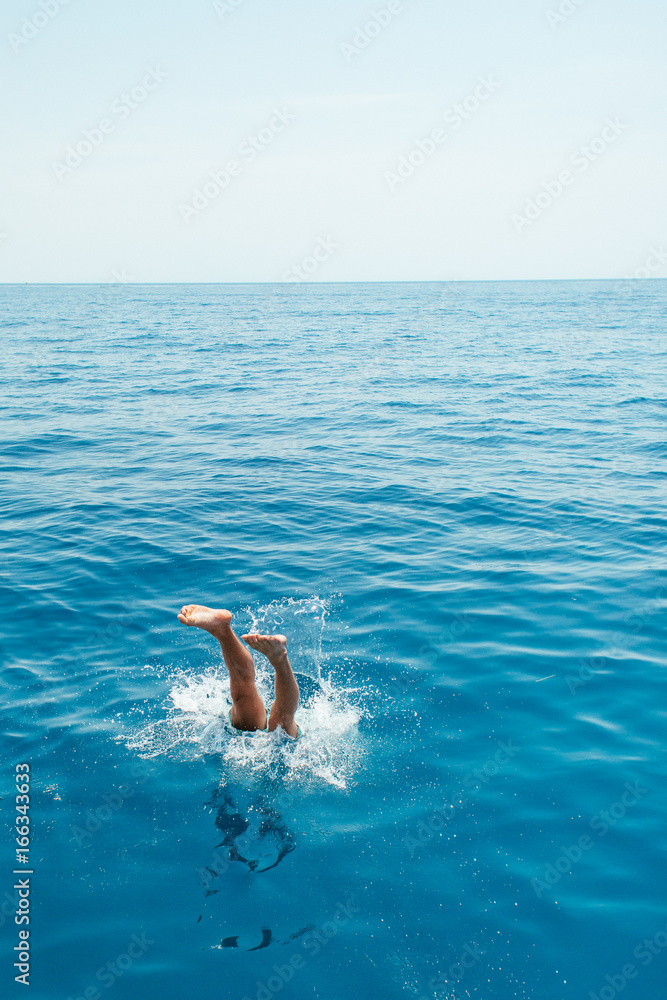 Young man jumping into the water