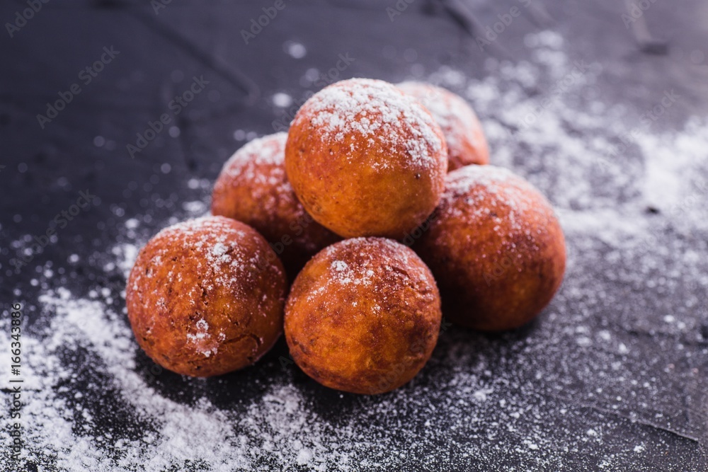 Curd balls sprinkled with sugar buds on a dark background Curd balls sprinkled with sugar buds on a dark background